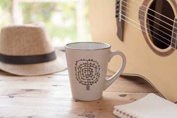 coffee cup and guitar on wooden table