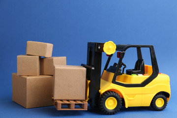 Forklift model and carton boxes on blue background. Courier service