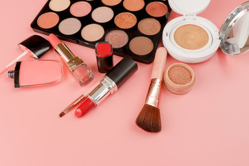 Various makeup productson pink background with copyspace