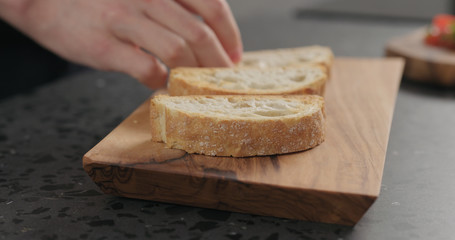 man hand put ciabatta slices on olive board