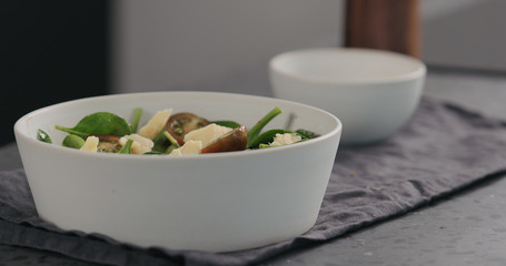 cheese chunks to salad with kumato tomatoes and spinach in white bowl