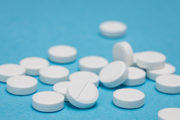 White round pills on a blue background