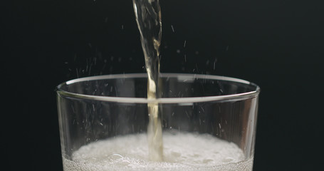 pour cider into glass with zoom out on black background