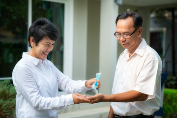 Old people in asia usd alcohol gel cleaning her hands for prevent a covid19 virus