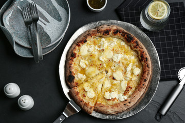 Tasty cheese pizza served on black table, flat lay