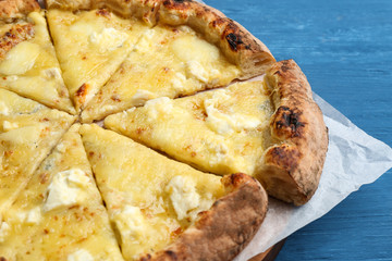 Tasty cheese pizza on blue wooden table, closeup view