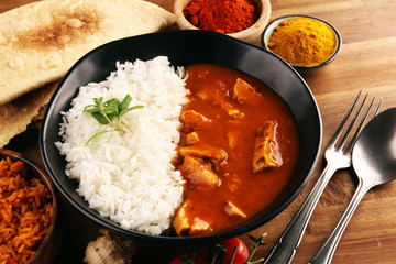 Chicken tikka masala spicy curry meat food in pot with rice and naan bread. indian food on table