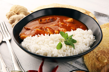 Chicken tikka masala spicy curry meat food in pot with rice and naan bread. indian food on table