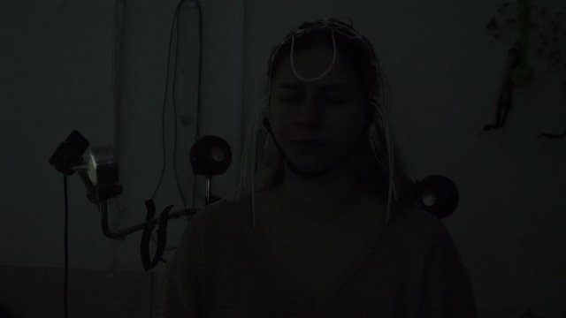 Electroencephalographic examination in clinic. Equipment for receiving brain EEG human. Female patient wired to EEG machine or electroencephalograph which produces graphical record of brain electrical