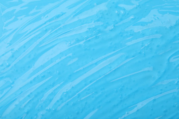 Fototapeta na wymiar Pure transparent cosmetic gel on light blue background, closeup