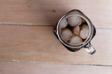 cola with ice in glass on wood table cola with ice in glass on wood table