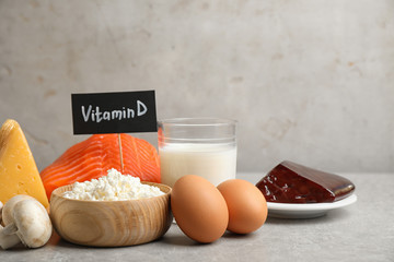 Paper with phrase VITAMIN D and fresh products on light table