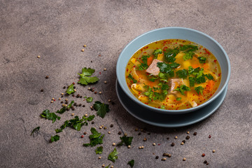 Delicious spicy soup with beef and noodle on grey background. Copy space for text.
