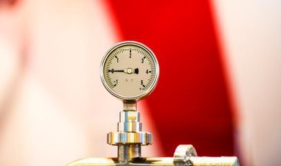 pressure gauge psi meter in pipe and valves of water system industrial focus left closeup white...