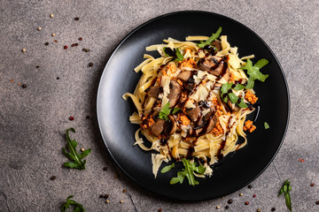 Bolognese pasta with mushrooms and arugula poured balsamic sauce. Top view. Copy space for text.