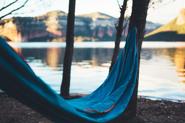 hammock for relaxing on background of nature lake, chilling outdoor, traveler recreation mountain landscape; camping lifestyle; enjoy weekend