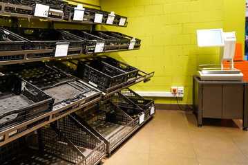 empty fruit and vegetable shelves in a European supermarket after buying food supplies because of...