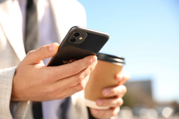 MYKOLAIV, UKRAINE - MARCH 16, 2020: Man holding iPhone 11 Black outdoors, closeup