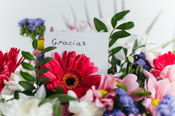 card thank you in spanish in a bright beautiful bouquet of flowers