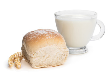 Freshly baked wheat bun and glass of milk isolated on white