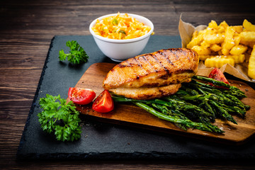 Grilled chicken fillet and vegetables on stone board