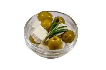Feta cheese cubes with green olives and rosemary in glass bowl isolated on white background