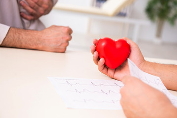 Old man visiting young male doctor cardiologist