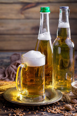 Light frothing beer in a glass, on an old background.