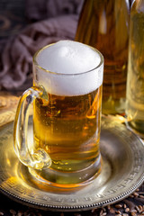 Light beer in a glass on a table in composition with accessories on an old background