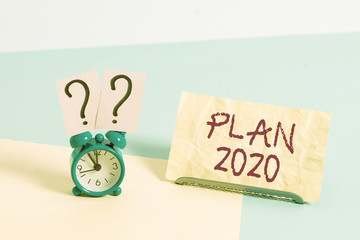 Conceptual hand writing showing Plan 2020. Concept meaning detailed proposal for doing or achieving something next year Alarm clock beside a Paper sheet placed on pastel backdrop