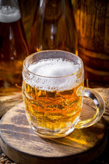 Light frothing beer in a glass, on an old background.