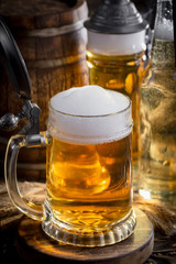 Light frothing beer in a glass, on an old background.