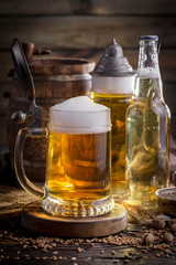 Light beer in a glass on a table in composition with accessories on an old background