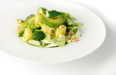 Green Salad with Avocado, Cucumber and Nuts on White Plate