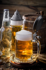 Light frothing beer in a glass, on an old background.