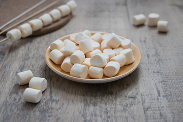 Fototapeta na wymiar A lot of sweet marshmallows in a brown plate