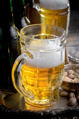 Light beer in a glass on a table in composition with accessories on an old background