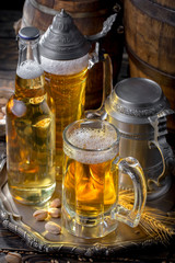 Light frothing beer in a glass, on an old background.