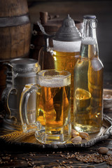 Light frothing beer in a glass, on an old background.