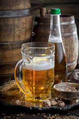 Light frothing beer in a glass, on an old background.