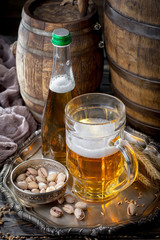 Light beer in a glass on a table in composition with accessories on an old background