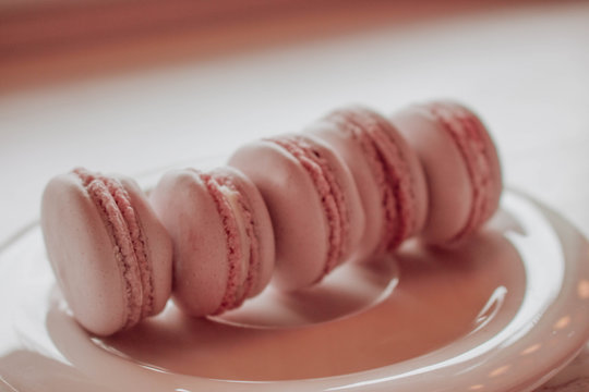Strawberry french macarons closeup. Fresh and colourful on pink background