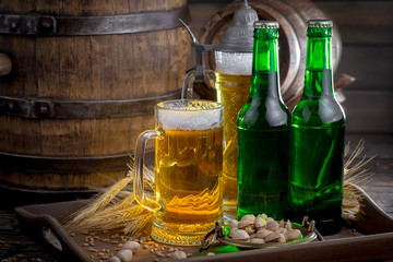 Light frothing beer in a glass, on an old background.