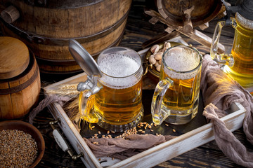 Light frothing beer in a glass, on an old background.