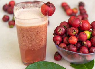 Glass of juice and fruits of red aracá (Psidium cattleyanum Sabine) in natura