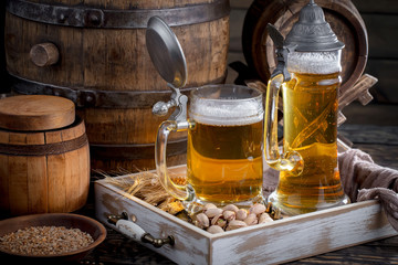 Light frothing beer in a glass, on an old background.
