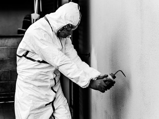 Healthcare worker with full white coverall disinfects from possible infection with Coronavirus...