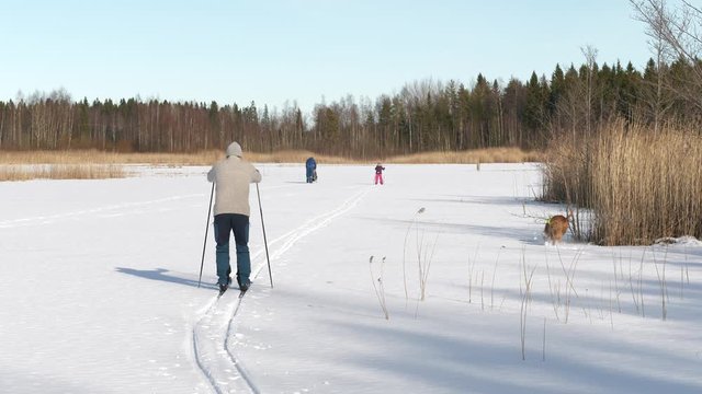 Happy family enjoying winter activities, Nordic skiing on snowy frozen lake