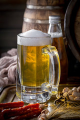 Light frothing beer in a glass, on an old background.