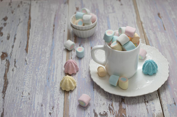 Color fruit marshmallows in the mug on the old pink table